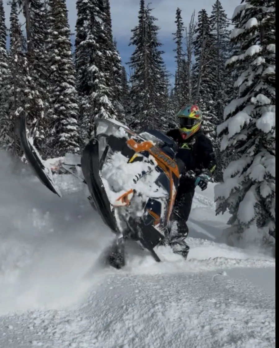 Snowmobile rider climbing mountain terrain