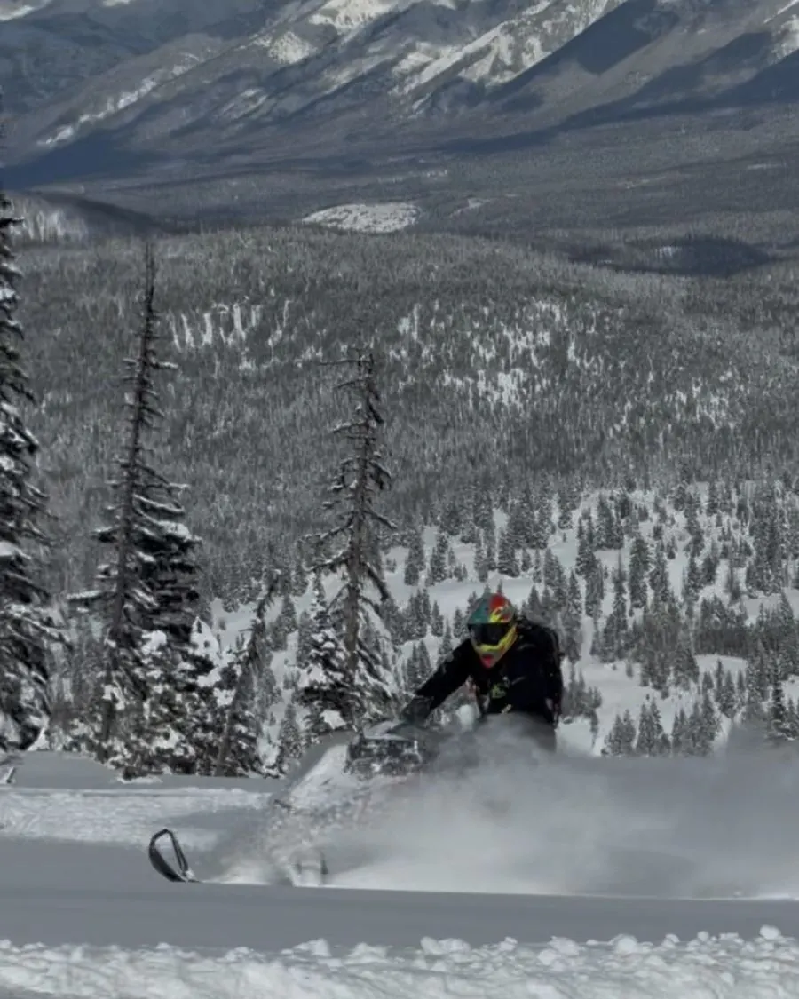 Snowmobile rider carving through deep powder